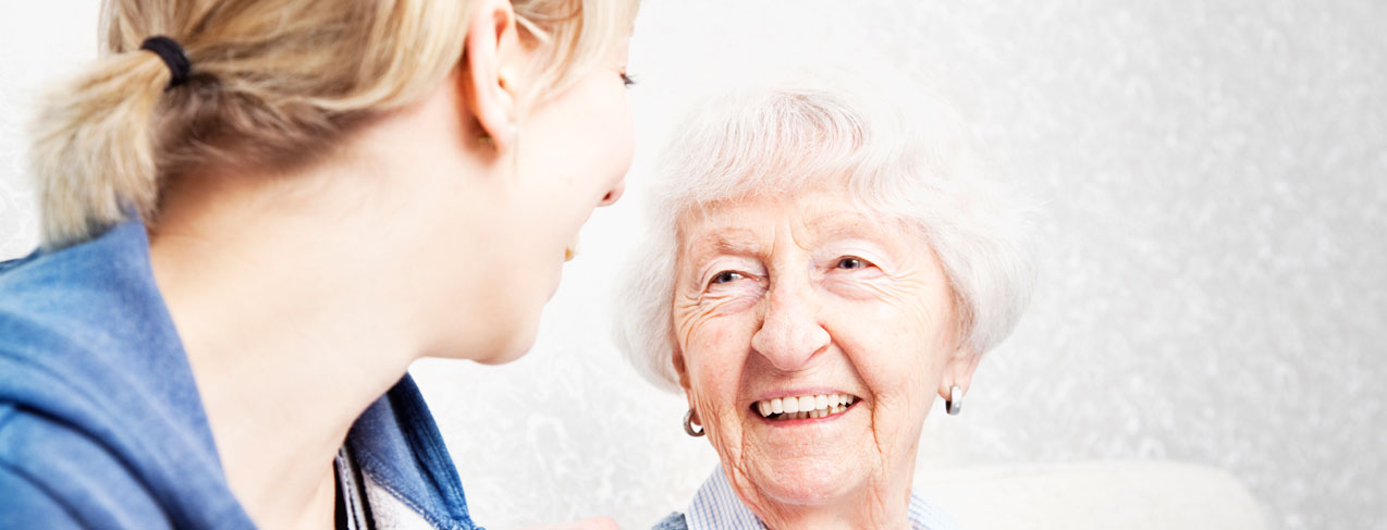 Home caregiver talking with senior woman